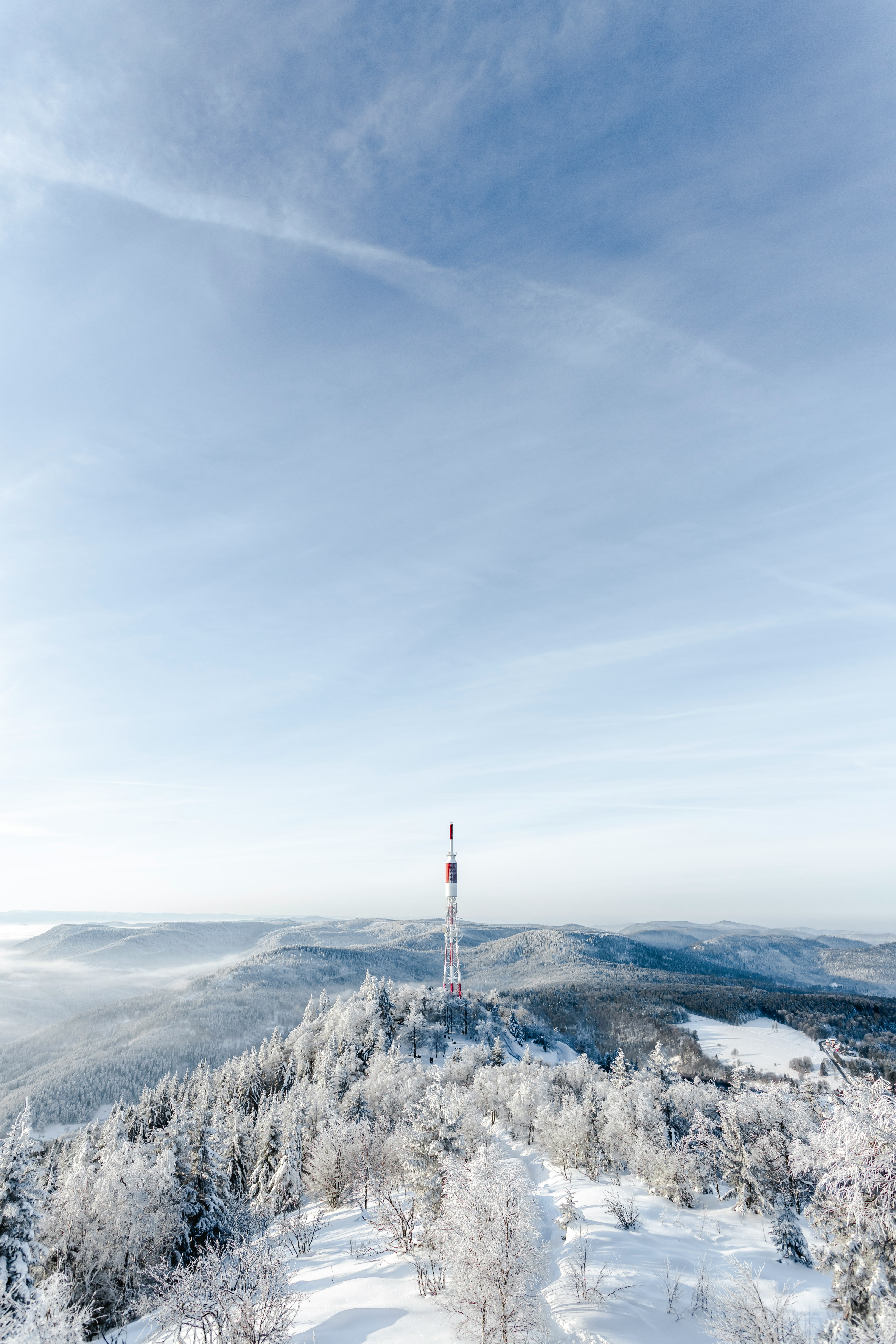 white and red tower on top of mountain